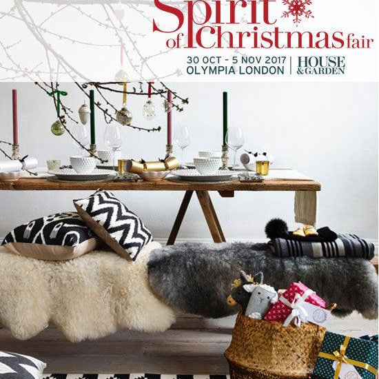 Christmas fair table setting with candles, gift basket, and cozy decor at Olympia London