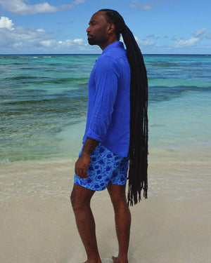 Caribbean beach style with at Lagoon Bay, Mustique island modelling men's linen shirt in dazzling blue