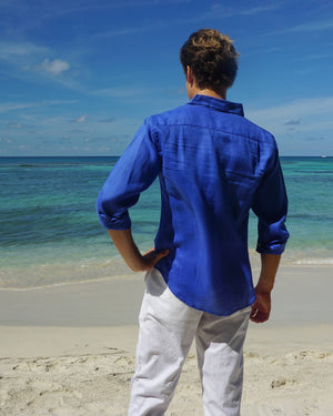 Men's linen holiday shirt in Caribbean dazzling blue worn on Lagoon Bay Mustique island