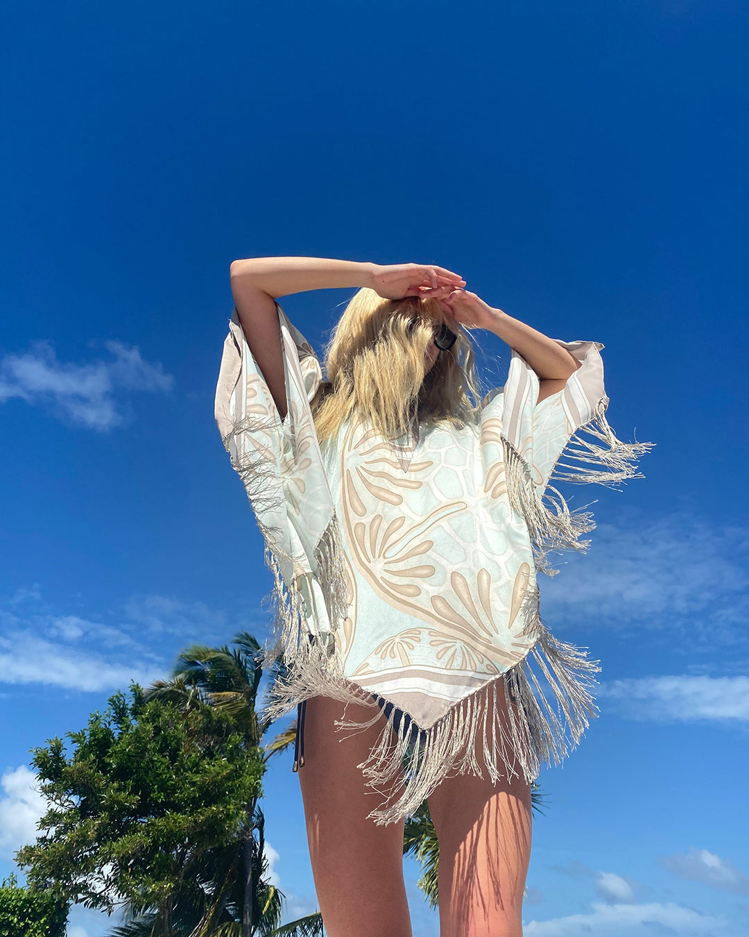 Sand Dollar pale blue taupe silk charmeuse fringed poncho by Lotty B worn in Caribbean resort setting