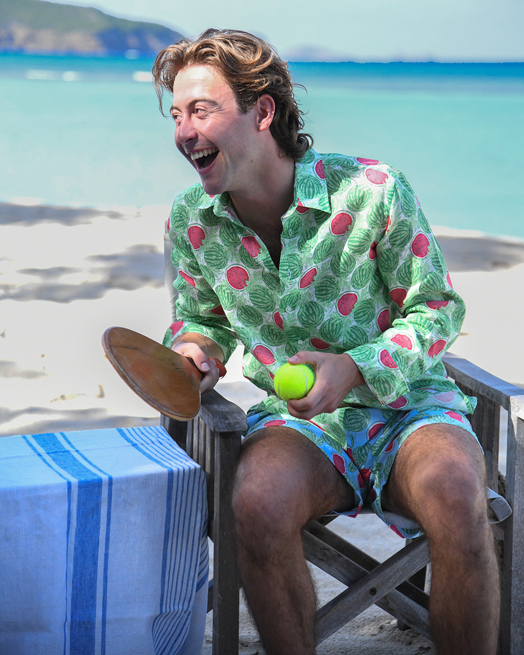 Man laughing in Watermelon Green linen shirt and matching swim shorts on a Caribbean beach