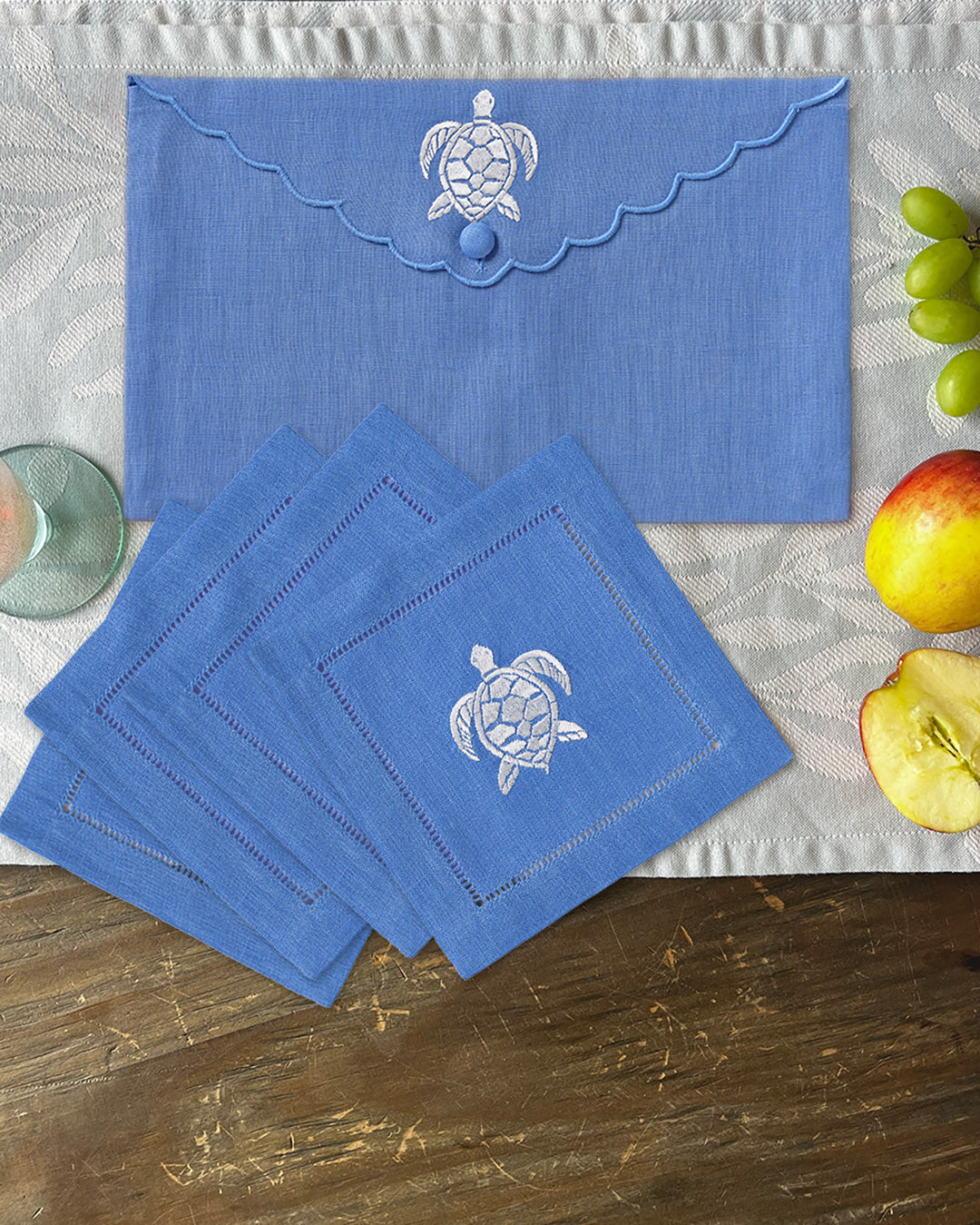 Azure blue linen cocktail napkins with turtle embroidery and matching envelope case, by Pink House Mustique.
