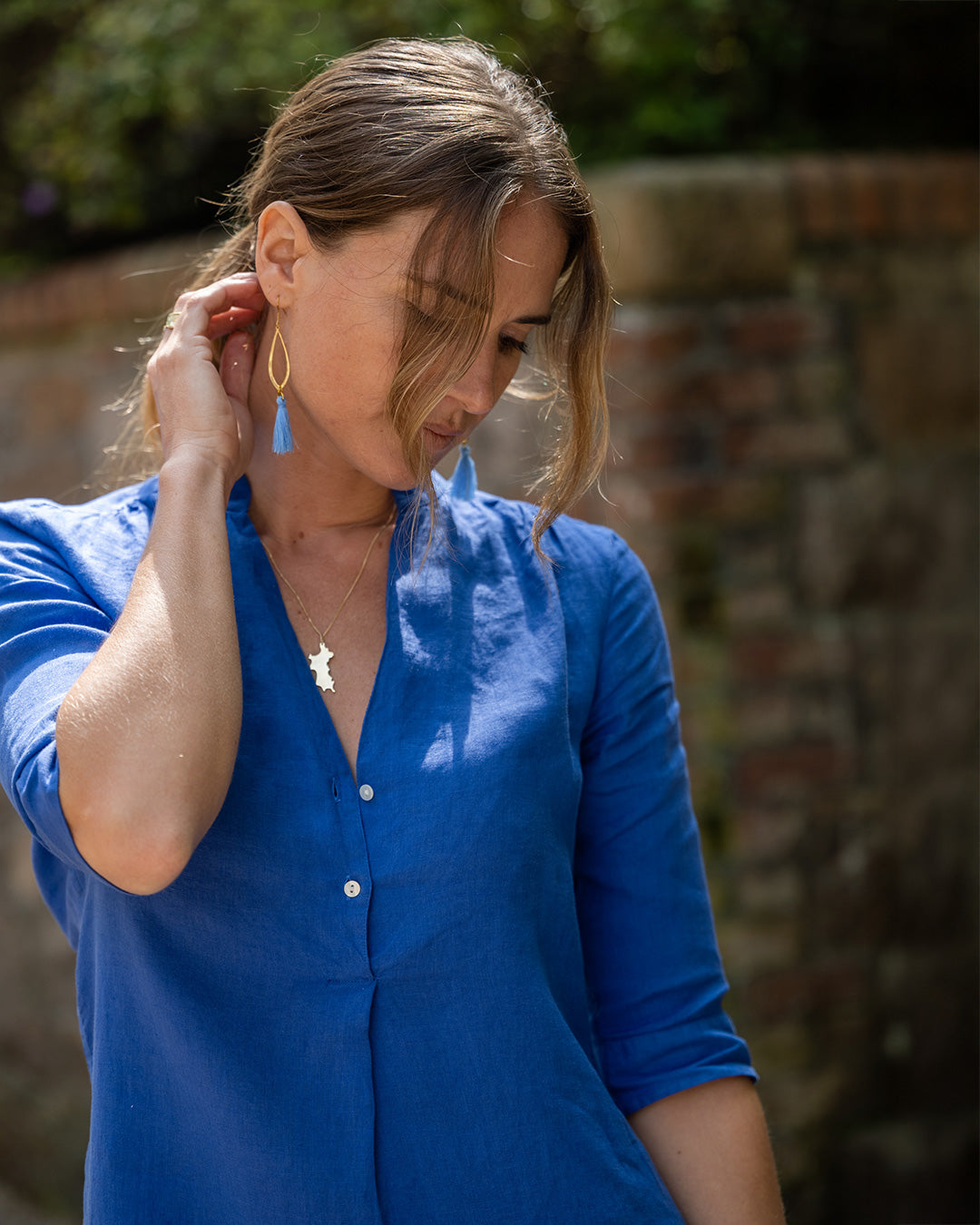 Hettie wearing 18K gold Mustique Island pendant necklace – delicate island-shaped jewelry, Mustique-inspired gift, luxury gold pendant for women