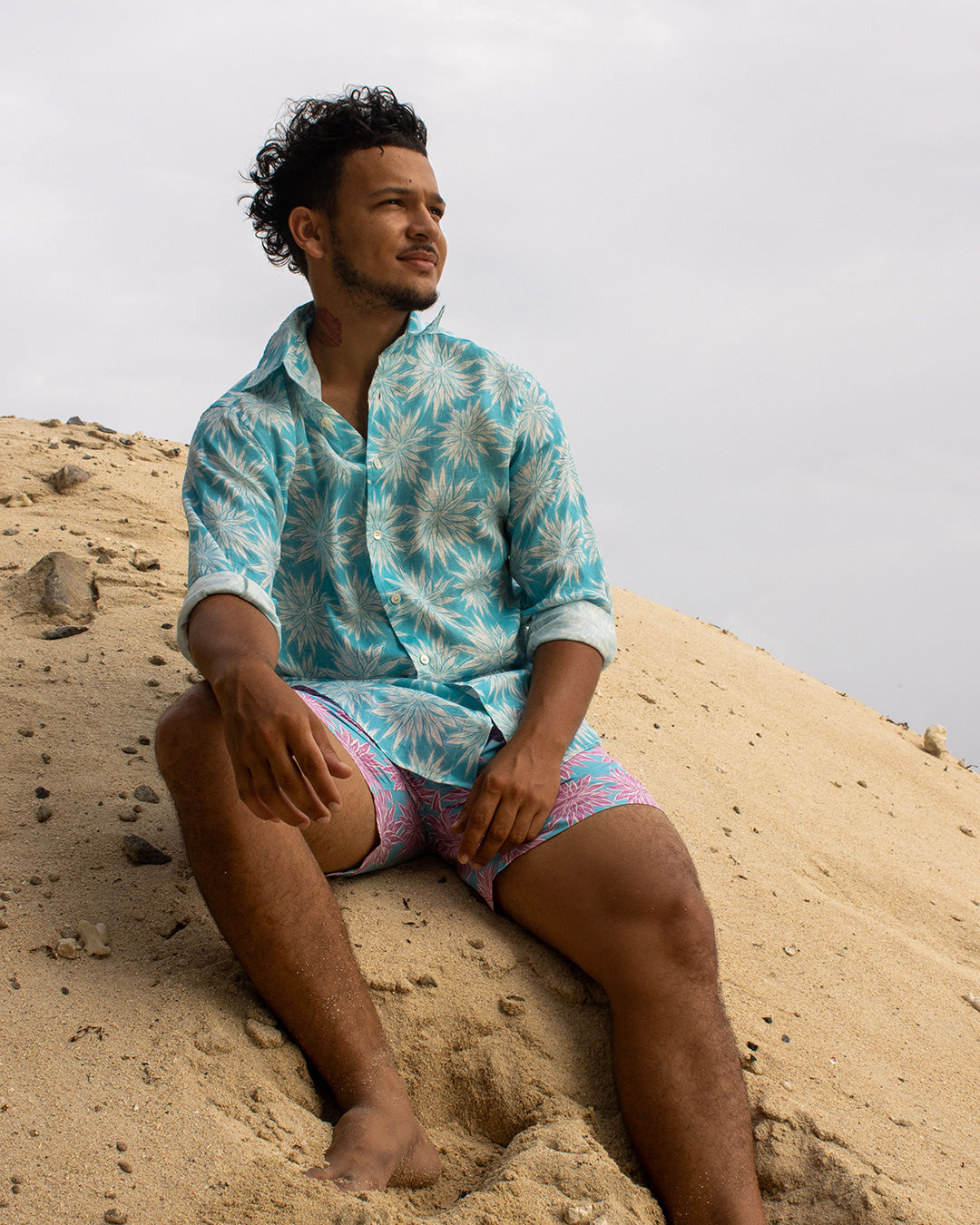 Men’s Agave turquoise linen shirt with Agave turquoise and pink swim trunks on Lansecoy Beach Mustique, Pink House Mustique.
