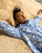 Men’s classic blue Iguana linen shirt by Pink House Mustique, relaxed tropical island style on the beach.