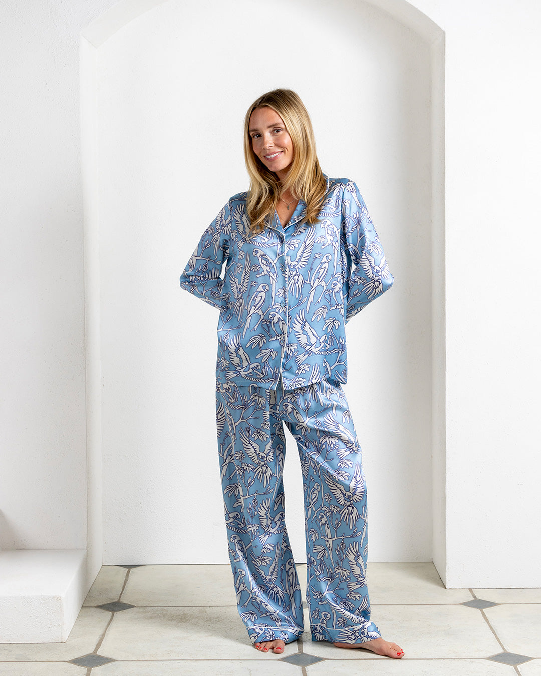 Model wearing Parrot Blue silk pajamas – women's designer loungewear by Lotty B Mustique in tropical parrot print