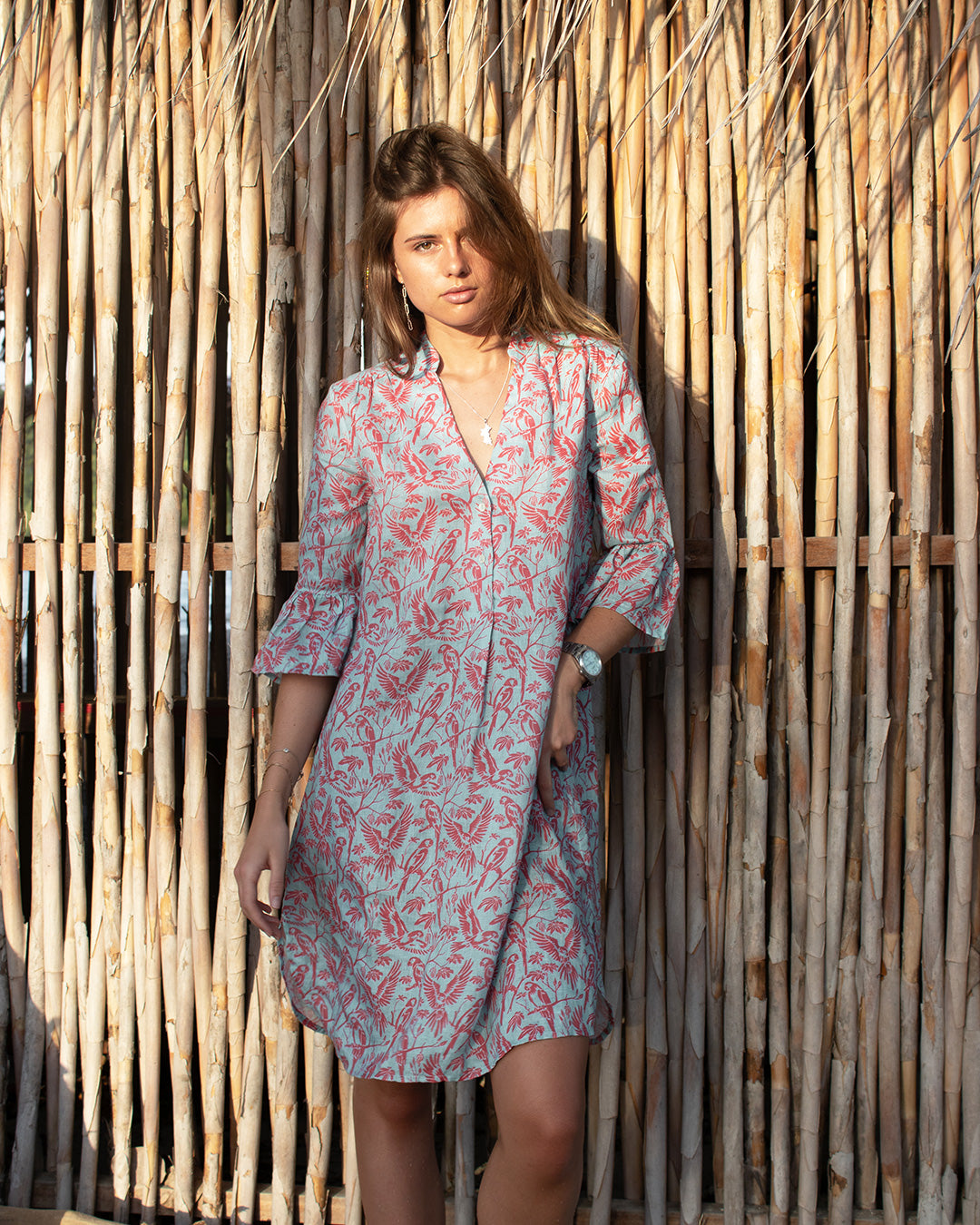 Lottie wearing Parrot Coral/Turquoise Decima Dress by Pink House Linen – breezy linen dress with V-neck and ¾ ruffle sleeves, designed for warm-weather elegance.