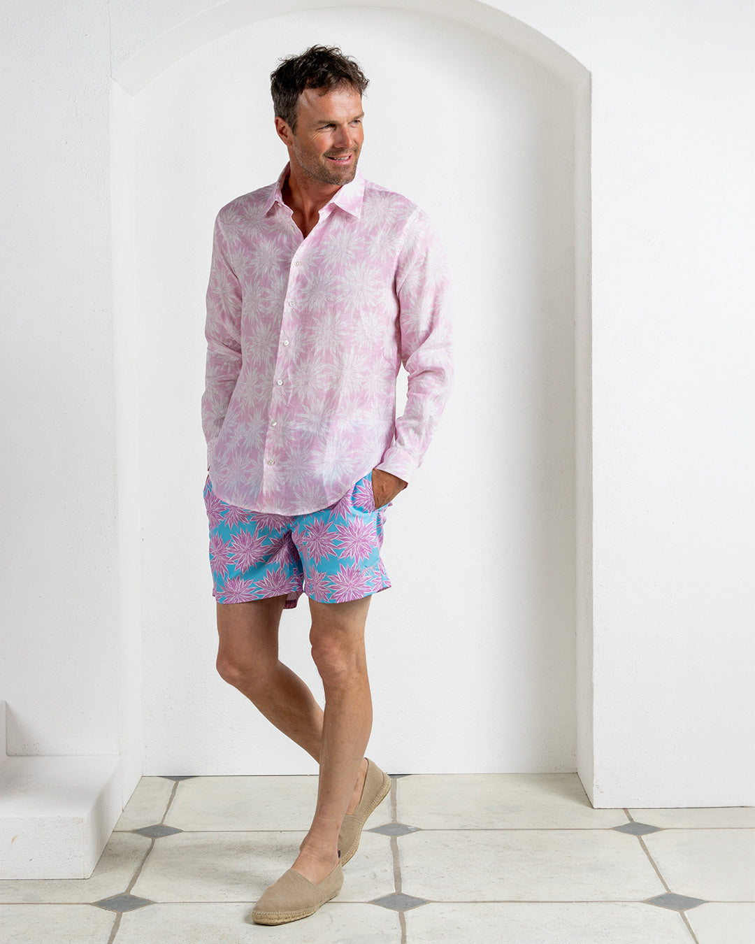 Back view of men’s Agave pink linen shirt with matching turquoise and pink Agave print swim shorts, made in Portugal.