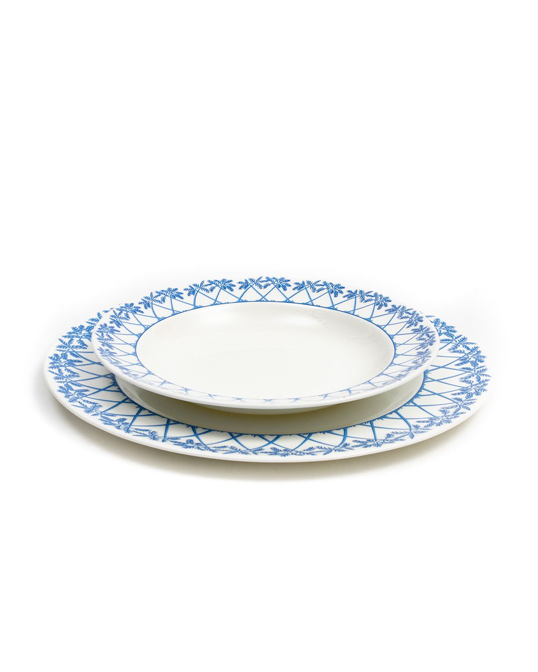 Showing the relative size of the dinner plate under the rimmed bowl in Palms Azure Blue design by Pink House Mustique.