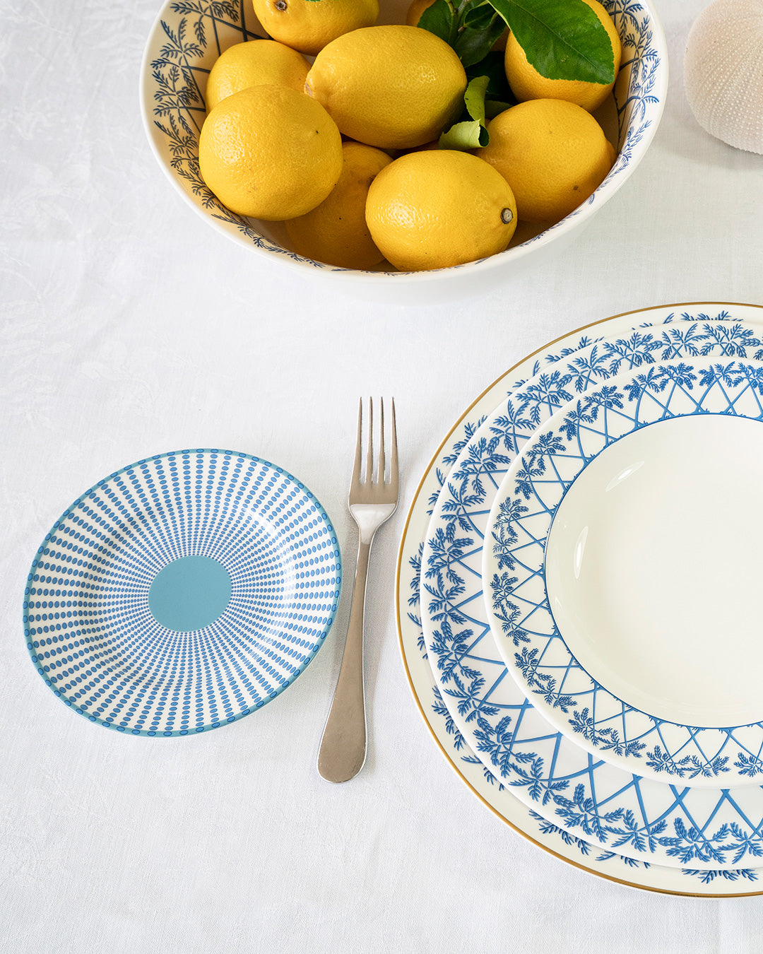 Fine bone china Palms Azure Blue side plate styled with matching charger and bowl — elegant coastal table setting with lemons.