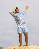 Men’s Iguana Blue linen shirt and swim shorts by Pink House Mustique — relaxed island style with sustainable design.