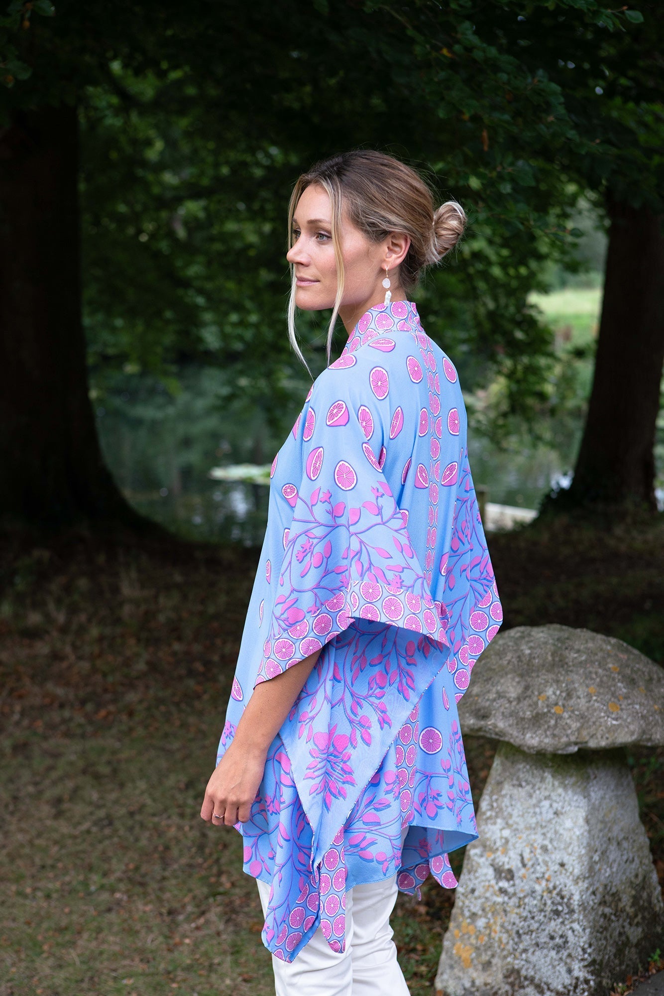 Side profile of woman in Jade Silk Poncho by Lotty B – luxury tropical loungewear in hand-printed citrus design, perfect for resort and garden parties.