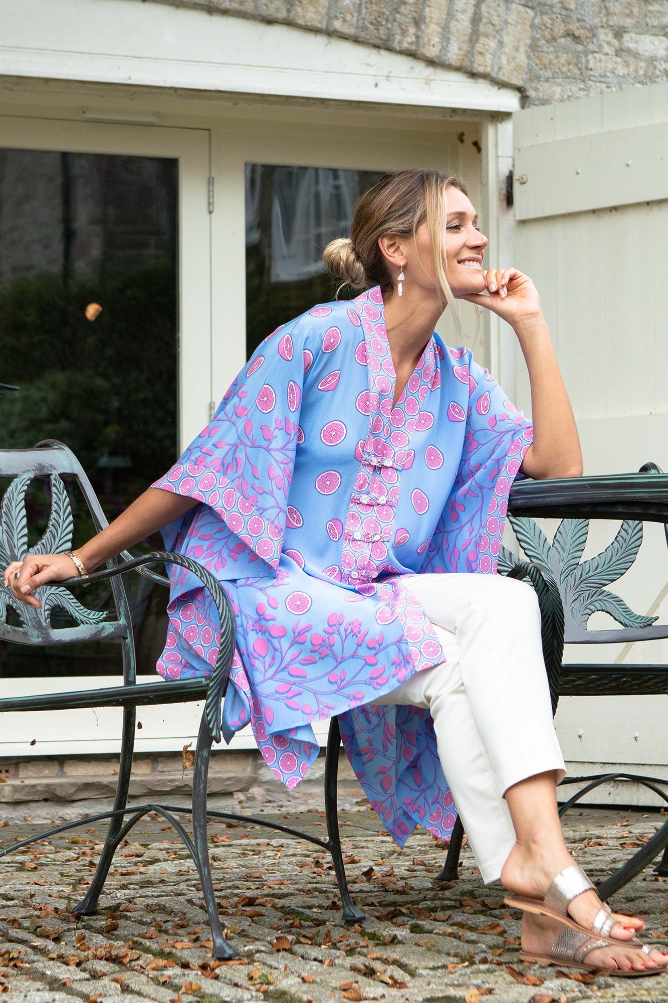 Silk Jade Poncho by Lotty B in Lime Tree print – luxury tropical cover-up styled with white trousers, combining artisanal design with elegant daywear.