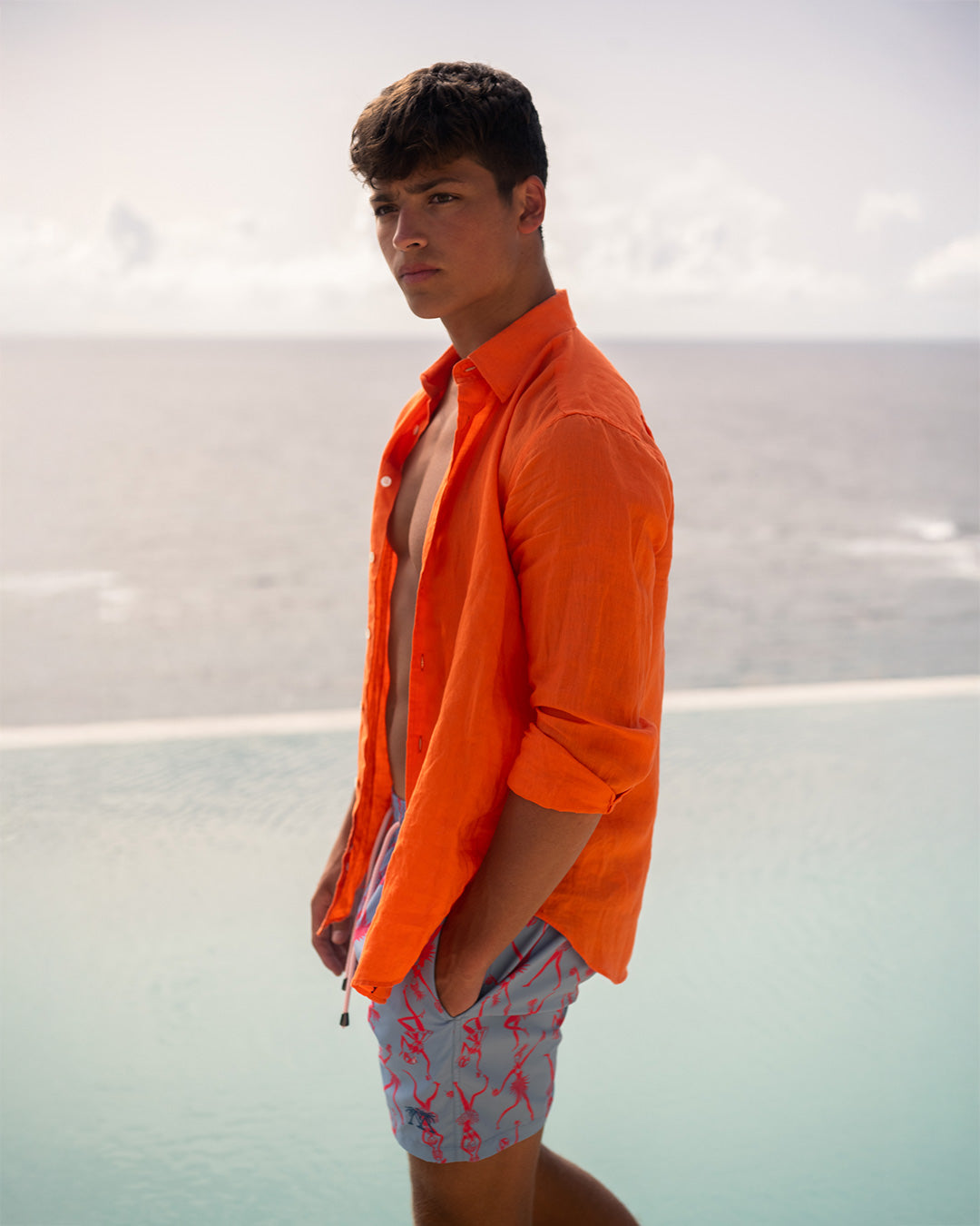 Men’s orange linen shirt by Pink House styled with swim shorts, effortless beach-to-bar summer look