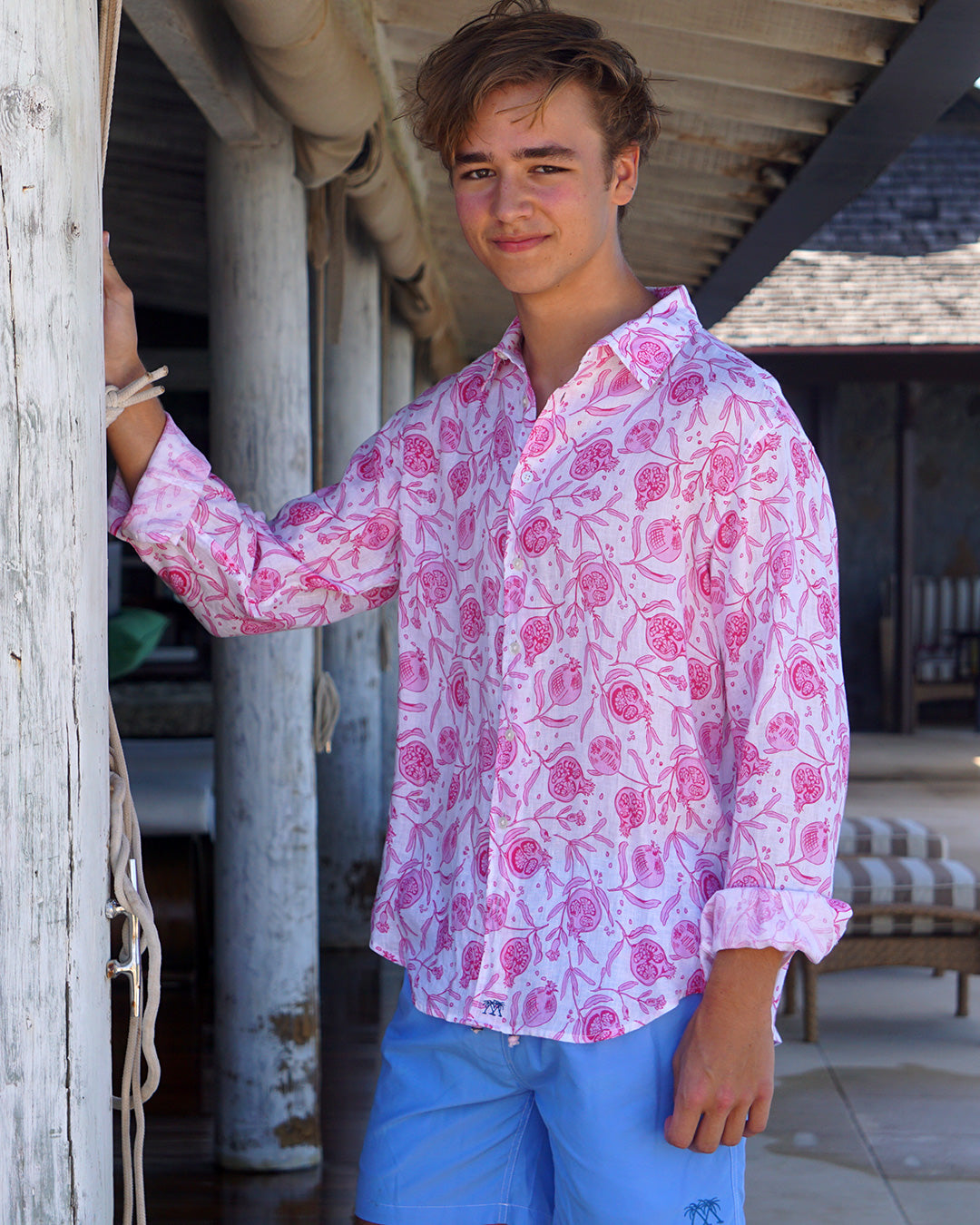 Unisex Pomegranate pink linen shirt styled by older brother with blue swim shorts at luxury Mustique resort villa