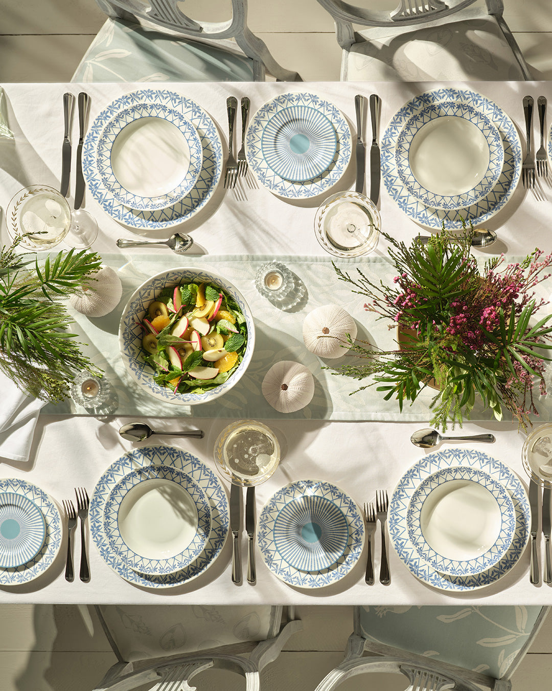 Elegant dinner table set with fine bone china Palms Azure Blue plates and serving dishes – luxury island inspired British tableware
