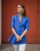 Side view of Sax Blue Decima linen dress with white pants – modern linen tunic outfit for women, perfect for layering