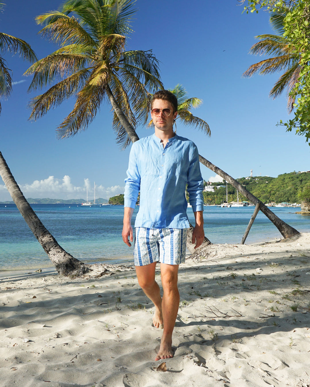Mens palm stripe swim shorts blue white styled with linen shirt luxury beachwear Mustique