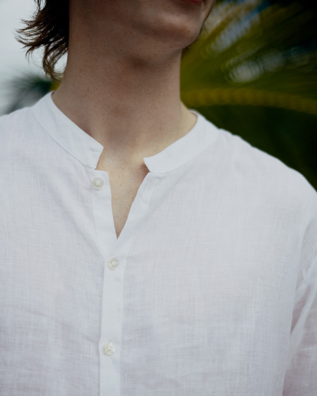 Close up of mens white linen shirt with grandad Nehru collar and buttons, lightweight breathable summer fabric
