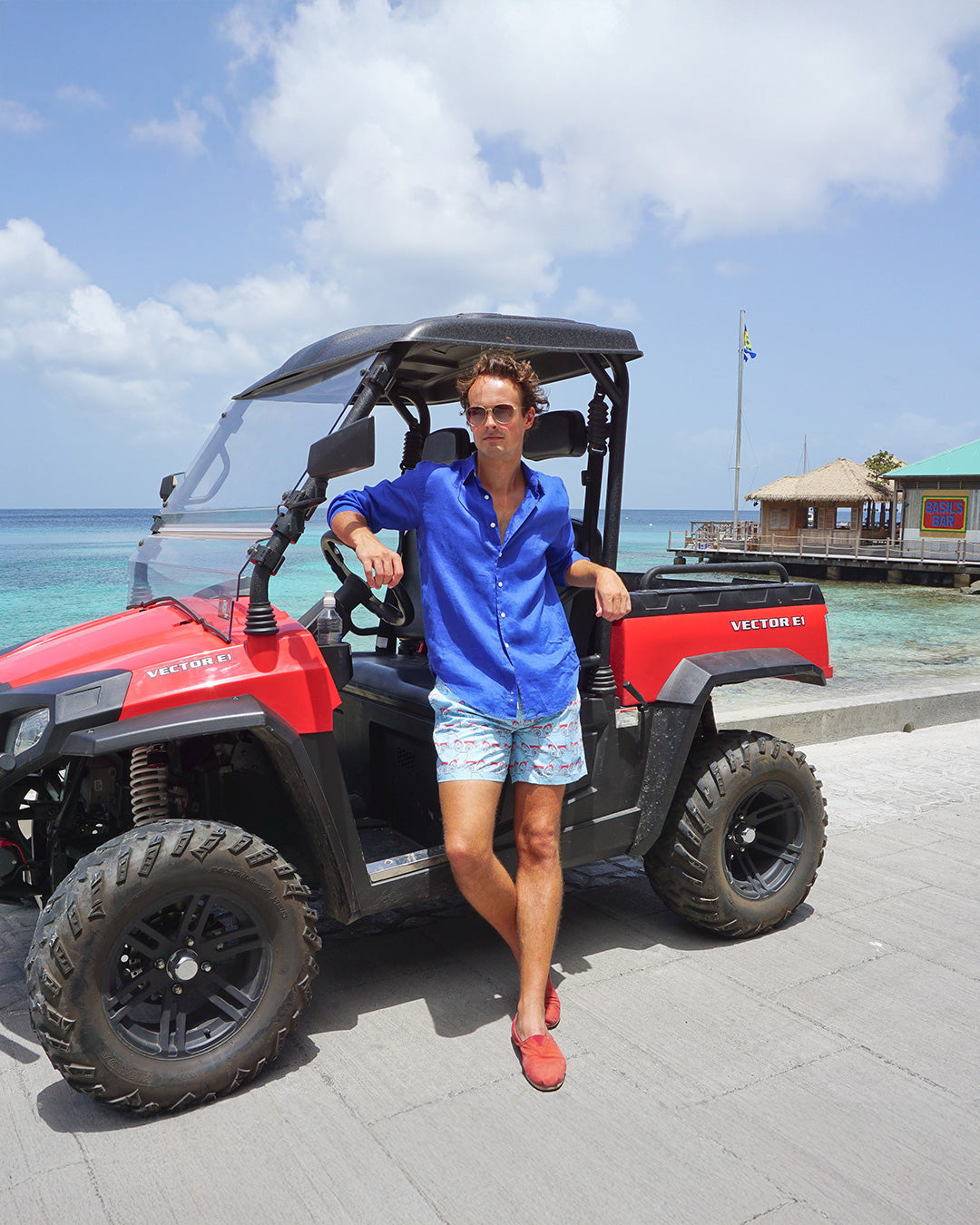 Men’s Mustique Mule red swim shorts and blue linen shirt at Basil’s Bar, Mustique