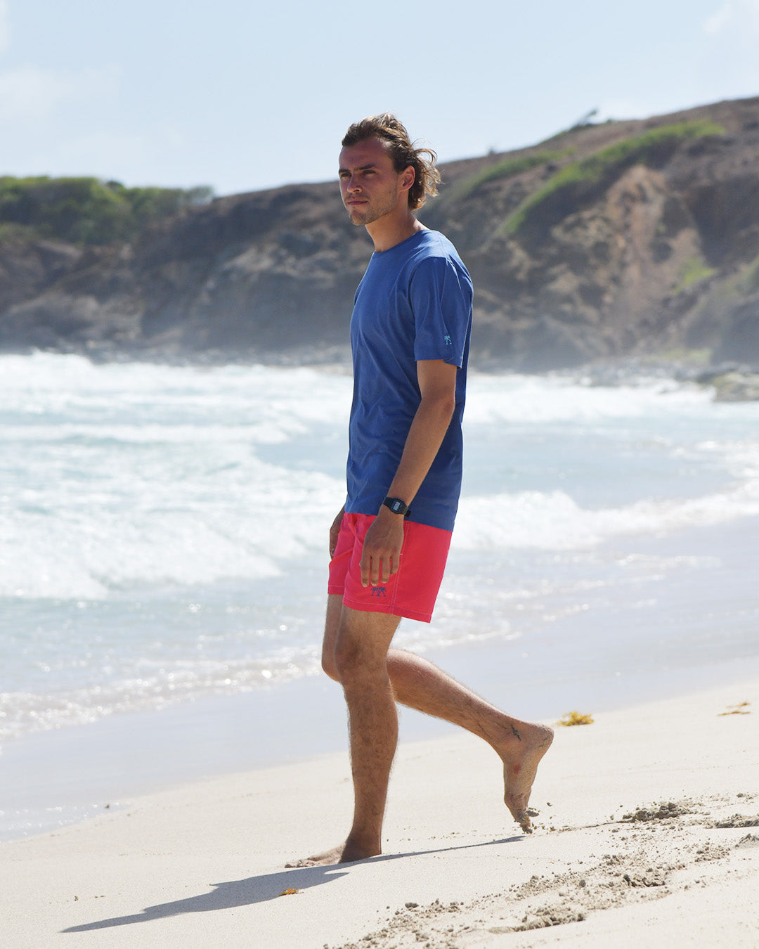 Men’s Pink House navy T-shirt and faded red swim shorts styled on the coast of Mustique Island