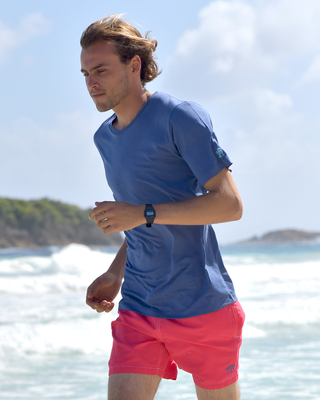 Pink House navy T shirt styled with faded red swim shorts on Pasture Bay, Mustique Island beach