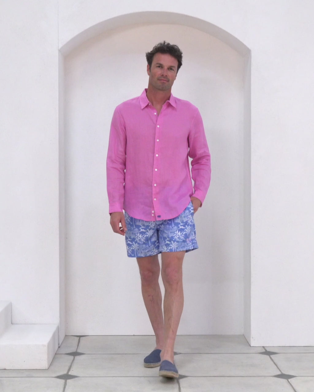 Pink House model Joss wears classic mens recycled, swim shorts in signature blue Toile de Jouy worn with fuchsia pink pure linen shirt