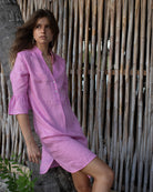 Lottie wearing Pink House Linen Decima Dress in solid Fuchsia Pink – elegant women's short linen dress with ¾ ruffle sleeves, perfect for tropical vacations, beach resorts, and summer style.