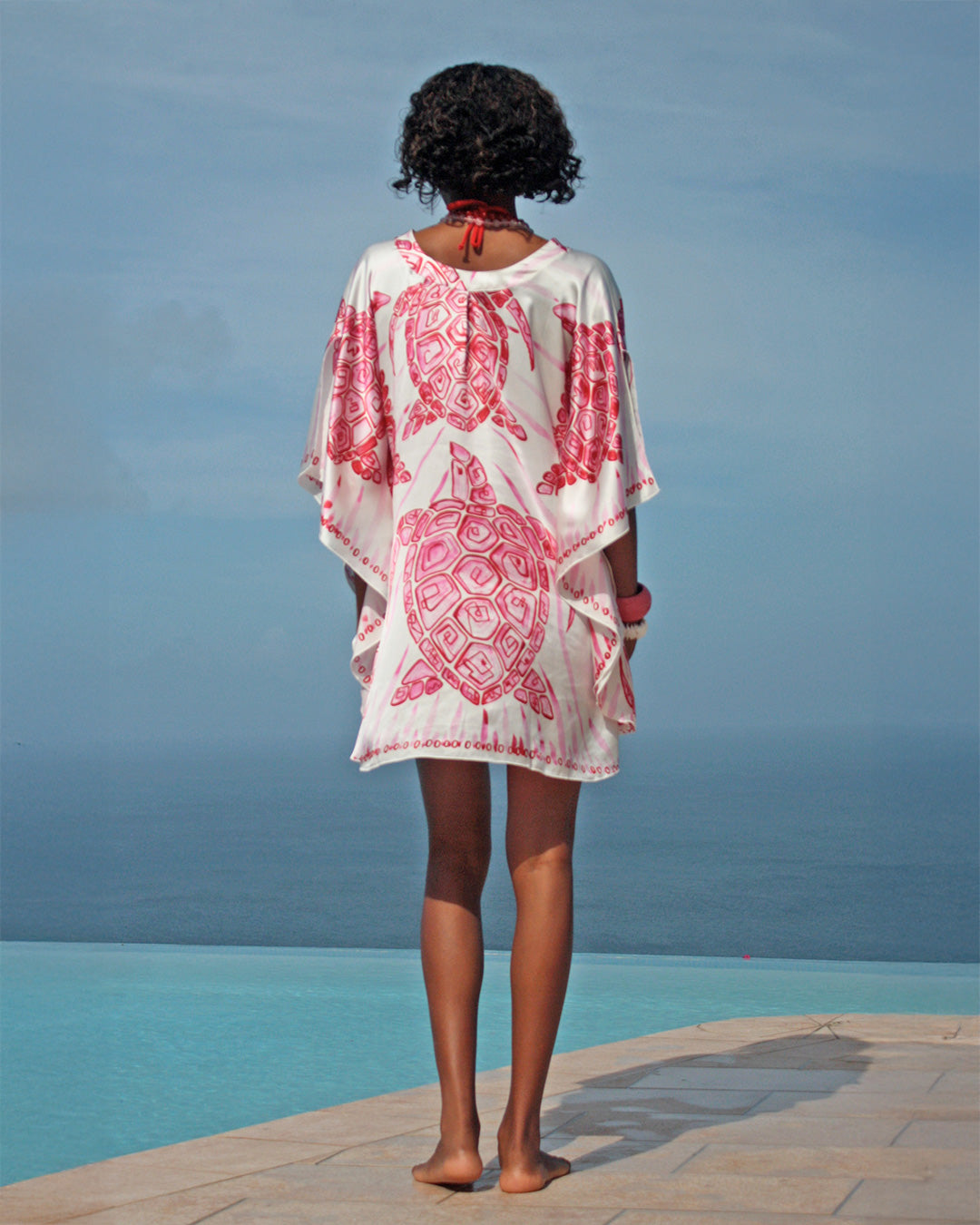Vintage Lotty B charmeuse silk kaftan in Turtle Pink, back view by infinity pool overlooking the Caribbean, Mustique.