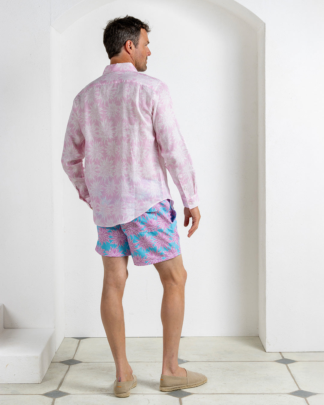 Men’s linen shirt in Agave pink styled with Agave turquoise and pink swim shorts, Pink House Mustique Resort 2026.