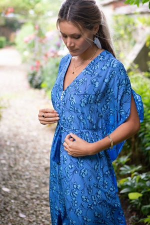 Summer party maxi dress, blue flamboyant flower print in silk by holiday styles designer Lotty b Mustique