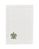 White linen placemat with sage green embroidered turtle – elegant island-inspired table linen by Pink House Mustique