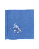 Blue linen napkin embroidered with white crossed palm trees – pure linen coastal tableware by Pink House Mustique