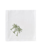 White linen napkin with green crossed palm embroidery – tropical table accessory by Pink House Mustique