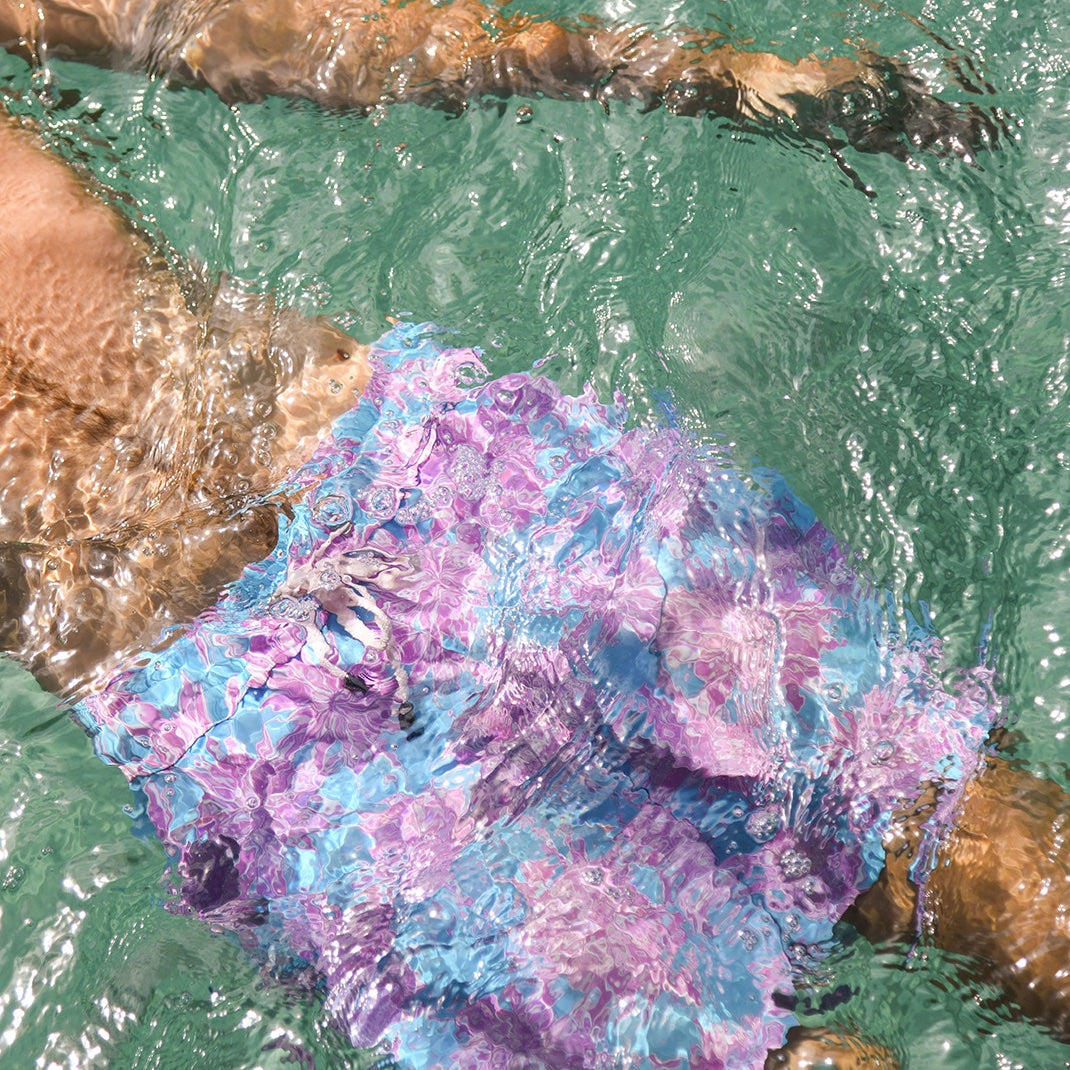 Colorful rubber duck floating in water near rocks