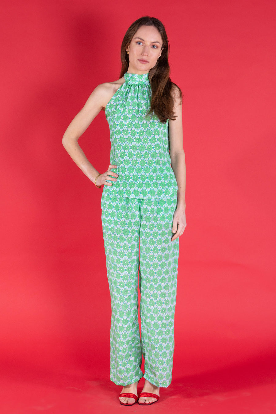 Handmade made to order Marina trousers in lime slice print silk crepe de Chine worn together with matching Olivia halterneck top from Pink House Atelier Collections