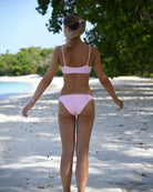 Back view of Lottie modelling Pale Pink Terry Bandeau Bikini on Lagoon Beach Mustique