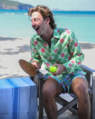 Man laughing in Watermelon Green linen shirt and matching swim shorts on a Caribbean beach