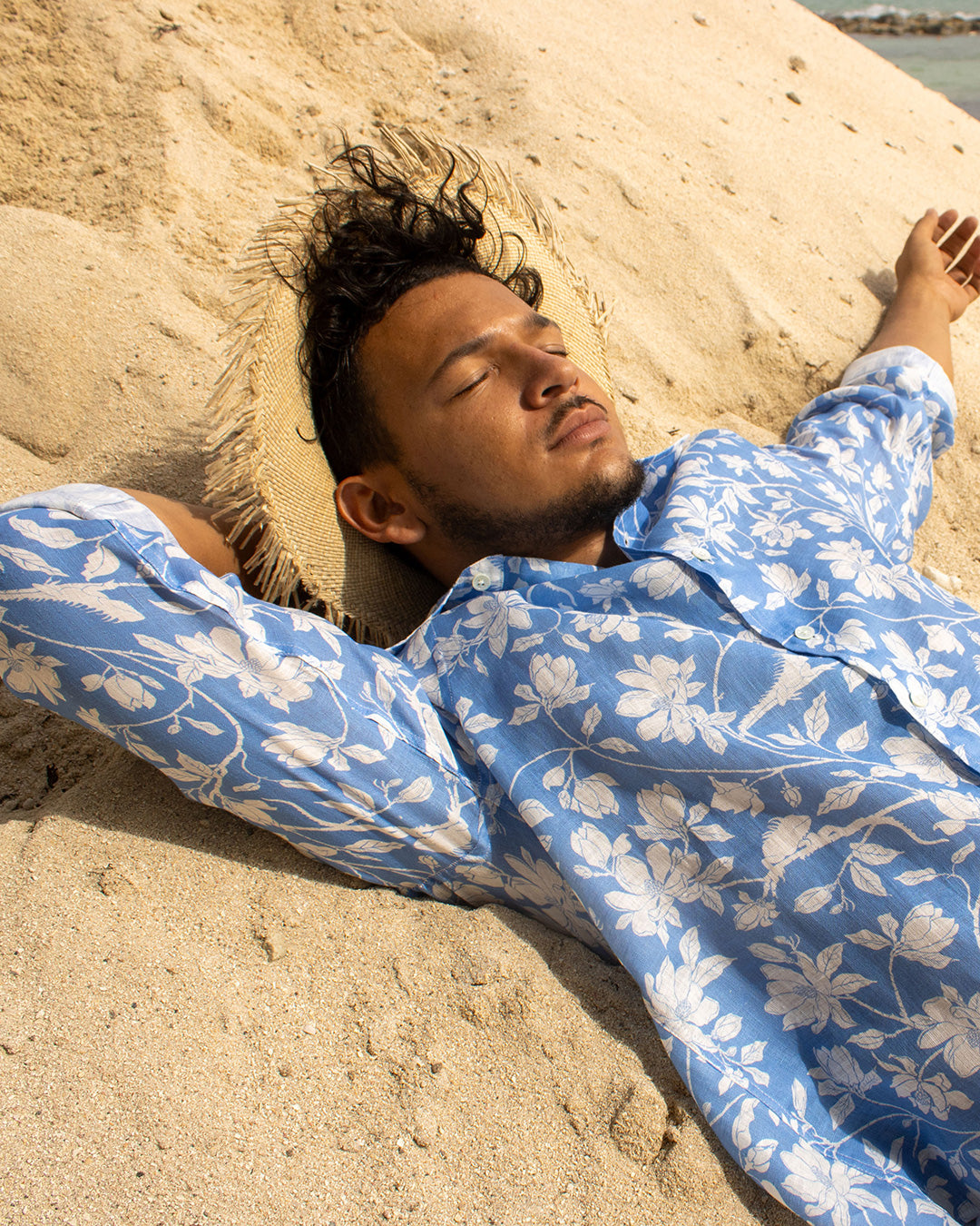 Men’s classic blue Iguana linen shirt by Pink House Mustique, relaxed tropical island style on the beach.