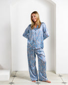 Model wearing Parrot Blue silk pajamas – women's designer loungewear by Lotty B Mustique in tropical parrot print