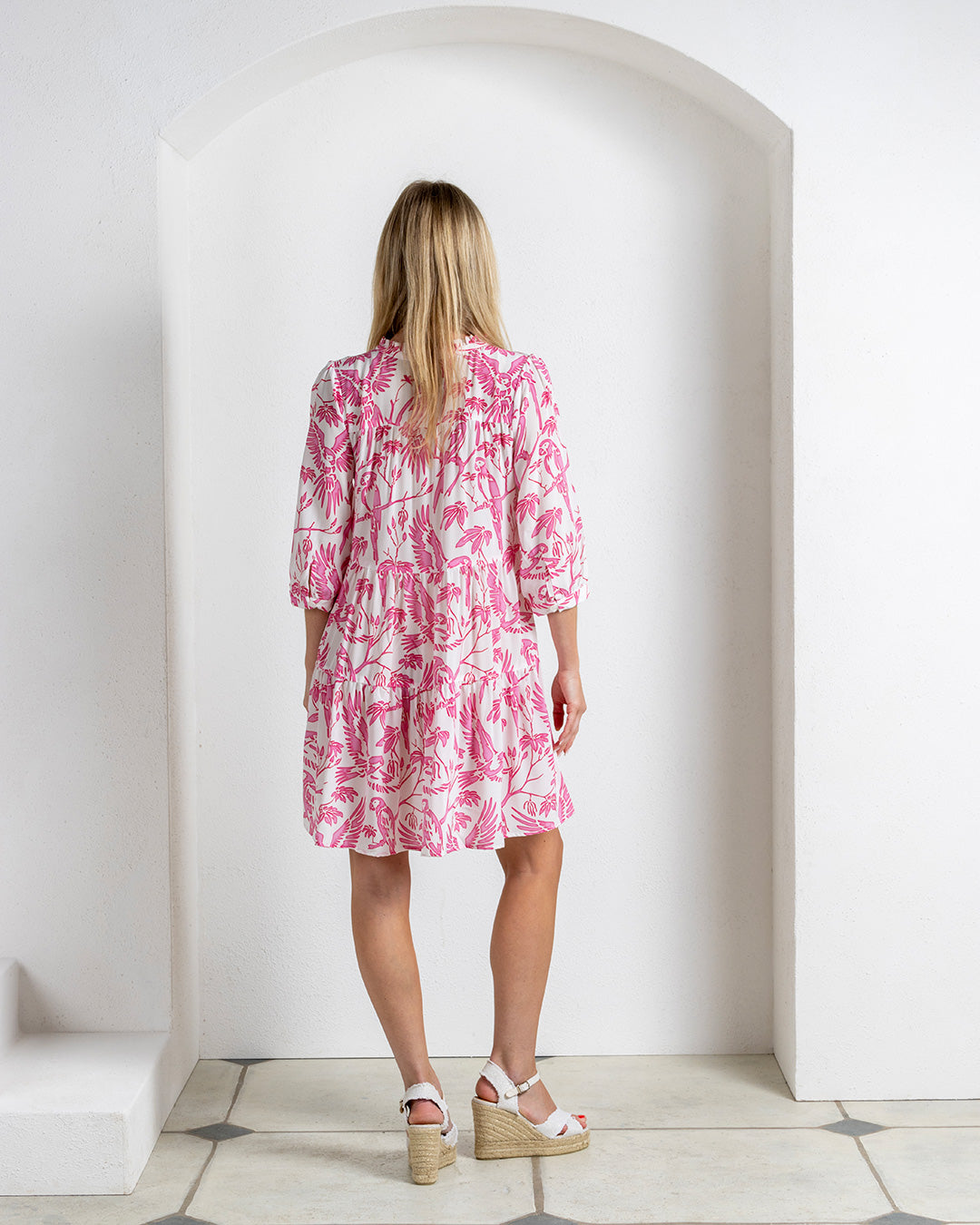 Back view of silk crepe Amy dress in Parrot pink – tiered skirt and soft gathers in tropical bird print luxury island style