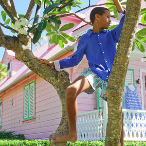 Climbing frangipani tree on Mustique in dazzling blue linen shirt