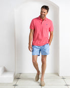 Men’s pink cotton polo with Coral Stone Blue swim shorts by Pink House Mustique, luxury resort style.