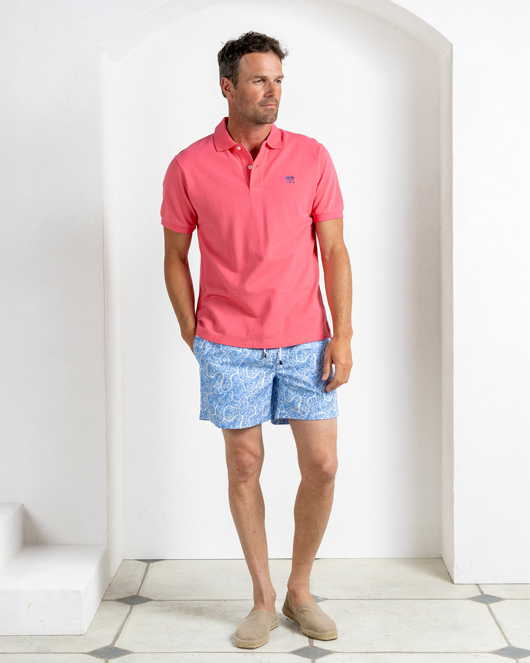 Designer men’s pink cotton polo with Coral Stone Blue swim shorts, island resort wear by Pink House Mustique.