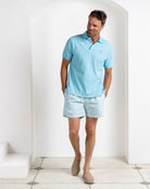 Designer men’s turquoise polo with Coral Stone Aqua swim shorts from Pink House Mustique Resort 2026.