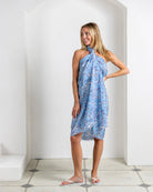 Model wearing Parrot Blue silk CDC sarong tied as beach dress – tropical bird print luxury resortwear