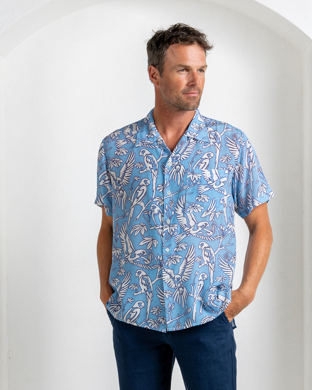Luxury men's silk shirt in parrot blue print, short sleeves, vacation-ready style from Pink House Mustique
