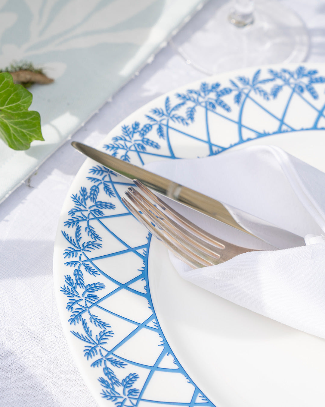 Close-up of Palms Azure Blue fine bone china dinner plate with intricate palm frond rim design.
