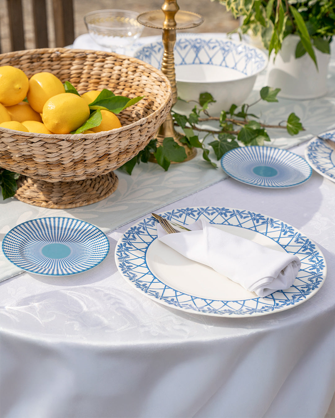 Elegant Palms Azure Blue fine bone china dinner set styled with lemons and linen napkins for luxury dining.
