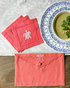 Embroidered linen gift bag in Palms Coral Pink styled with matching turtle embroidered cocktail napkins